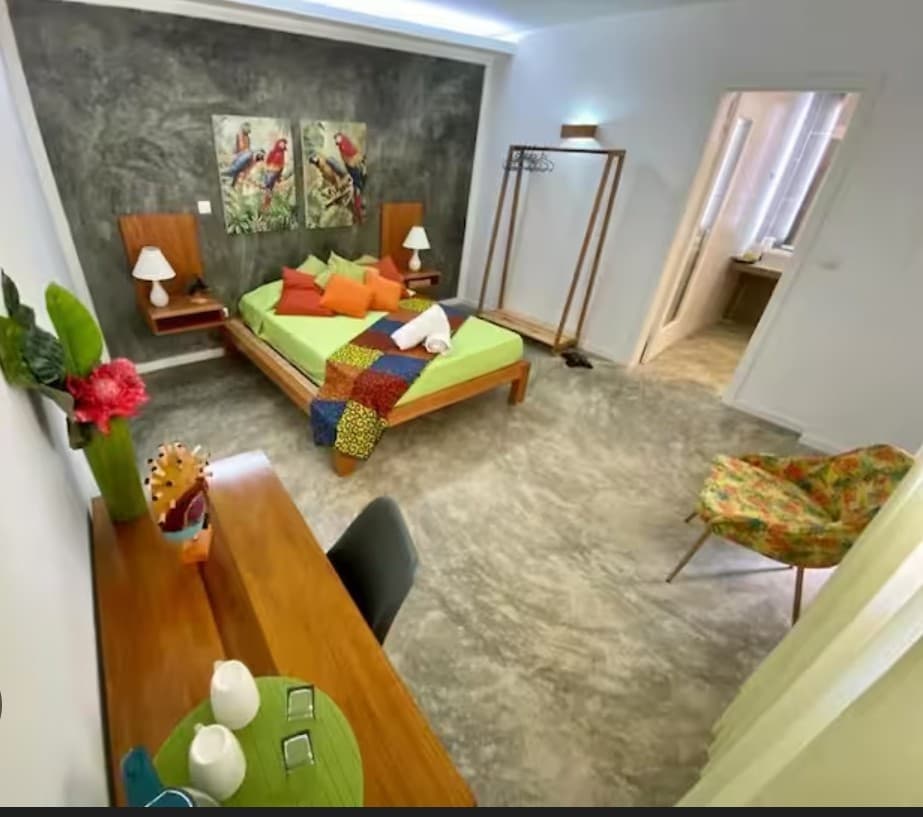 Quarto tropical com detalhes coloridos no Kriola Hotel